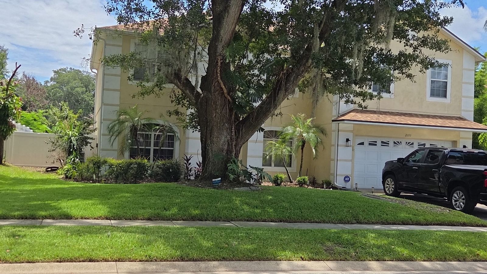 Two-story Central Florida home with a freshly mowed, trimmed front lawn